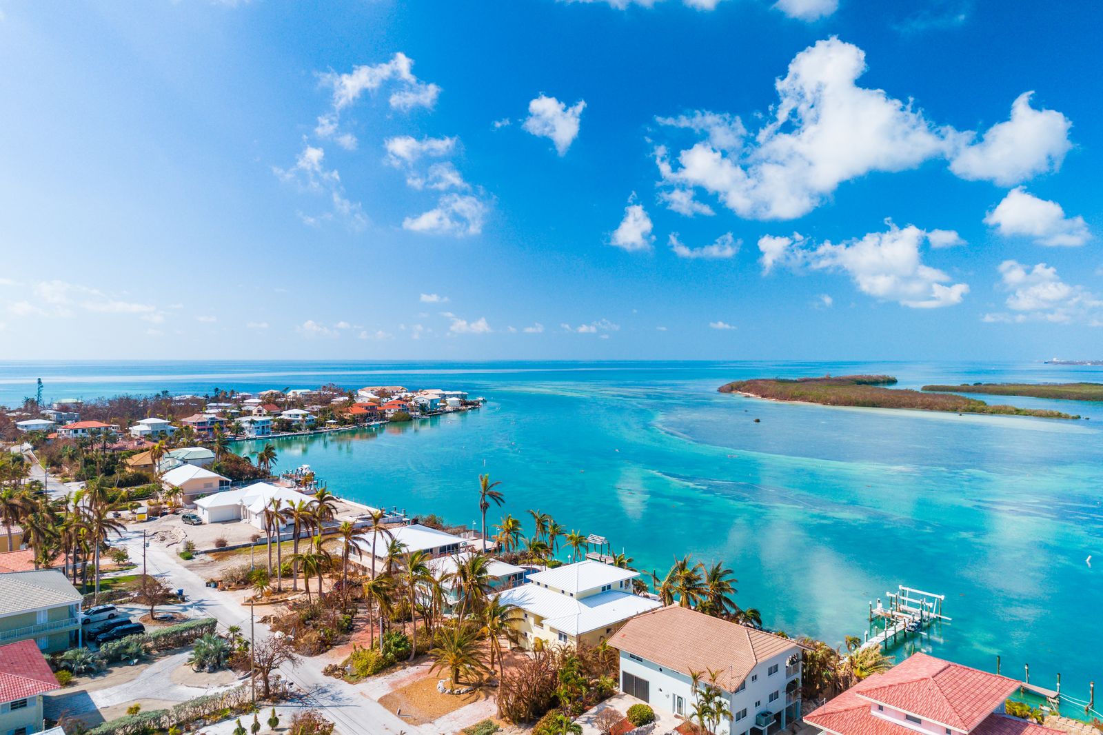 Waterfront homes and canals on a Florida Keys island under puffy clouds