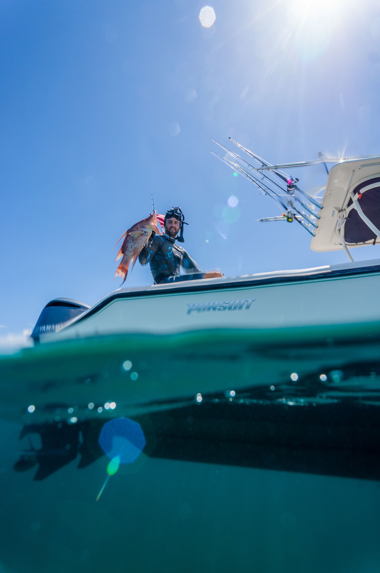 A split view of a boat above the waterline and clear blue water below