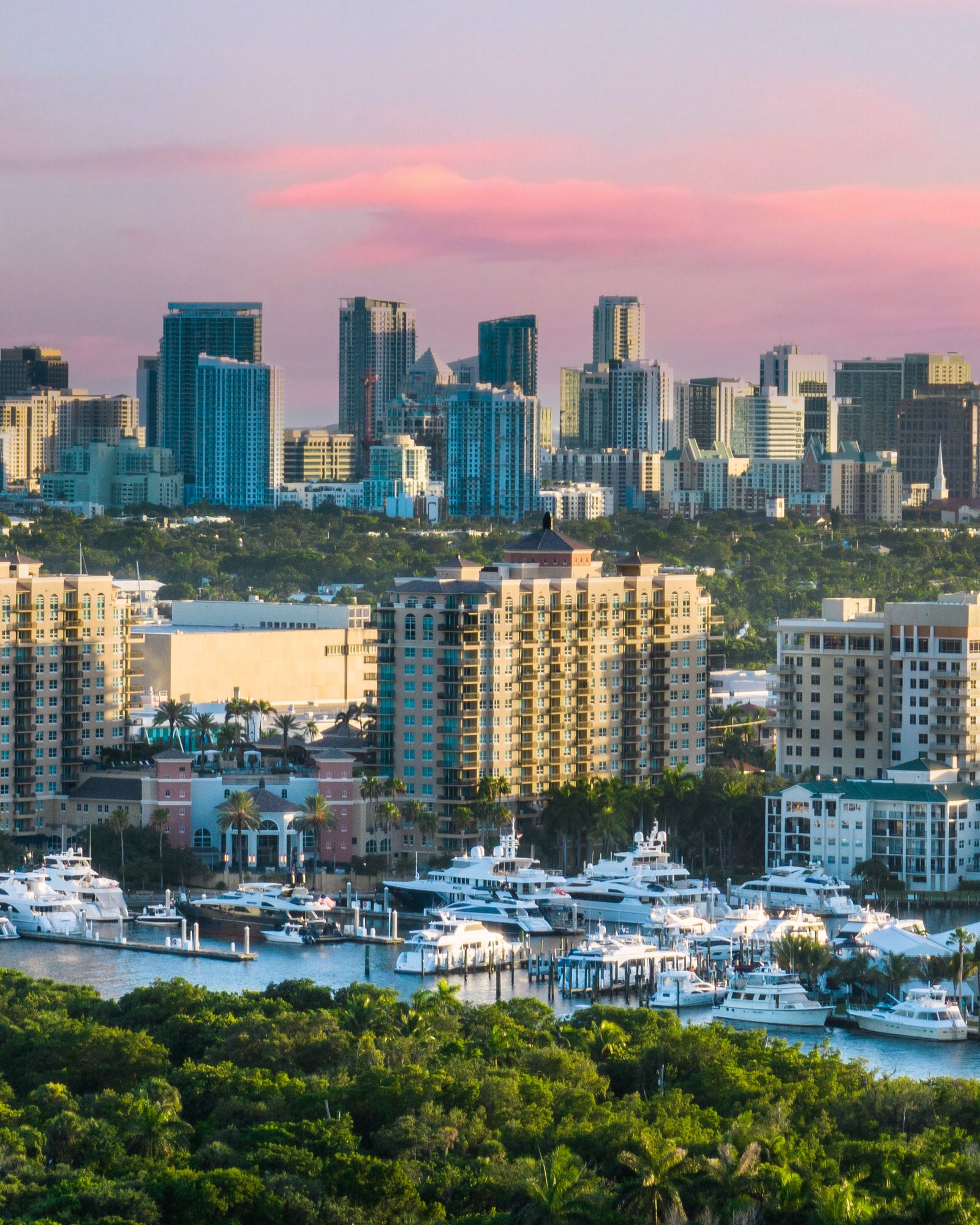 The West Palm Beach skyline at sunset above a marina full of yachts